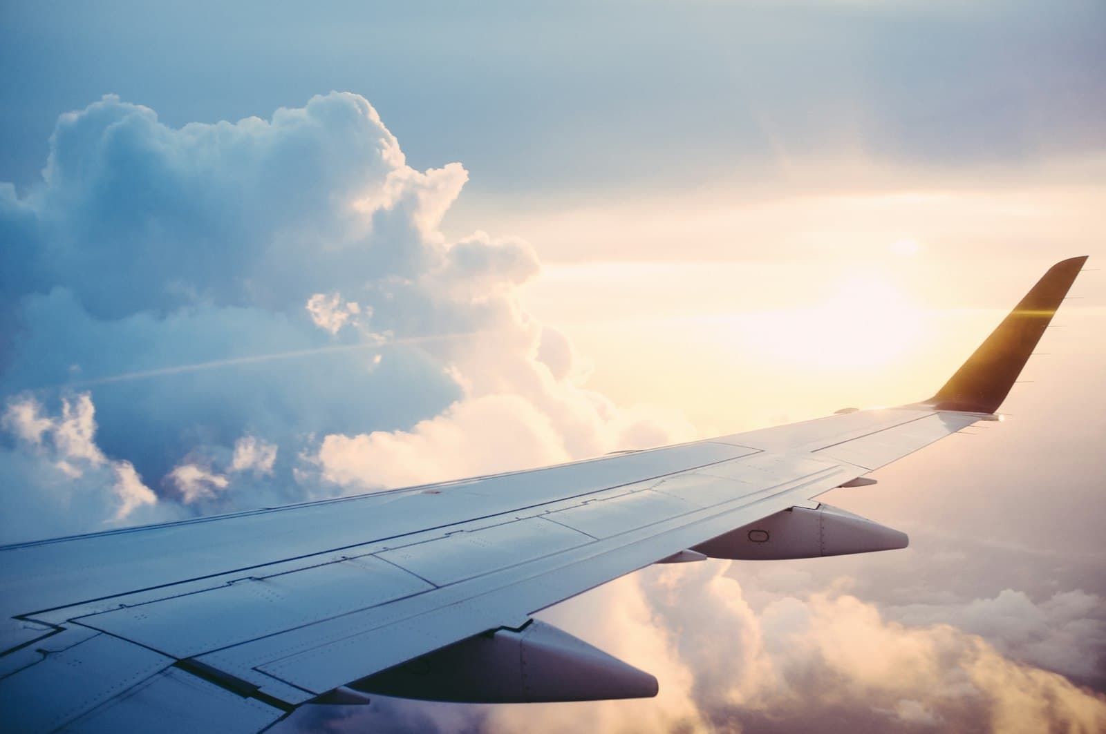 Aircraft wing above the clouds in warm evening light